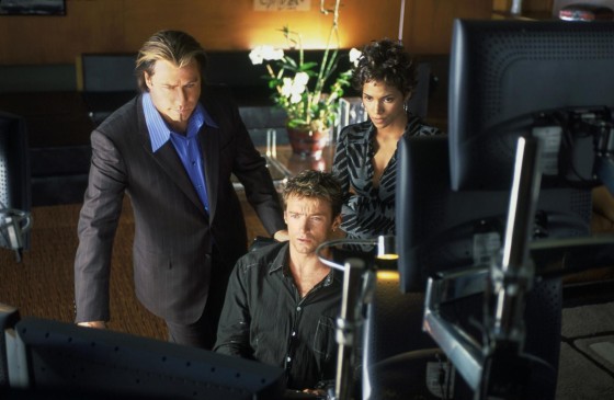 A still from the movie Swordfish showing Hugh Jackman sitting at a computer. Halle Berry and John Travolta are looking at the screen with him.