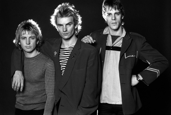 A black and white photo of the band The Police. Sting is in the center wearing an old-timey beach strongman shirt under a suit jacket. I honestly don't know anything about the rest of the band.